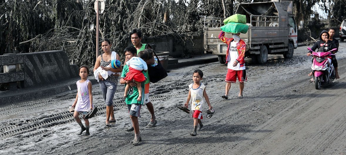 A family affected by the eruption of the Taal volcano in 2020 walks in volcanic ash-covered streets. A family affected by the eruption of the Taal volcano in 2020 walks in volcanic ash-covered streets.