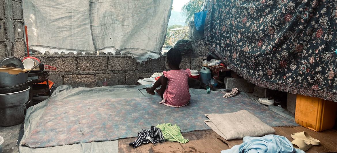 A young child whose family fled violence sits in a makeshift shelter in Port-au-Prince. A young child whose family fled violence sits in a makeshift shelter in Port-au-Prince.