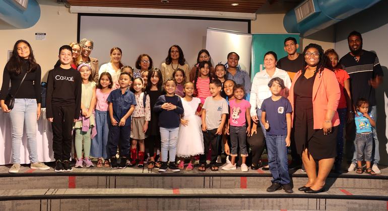 Venezuelan students join their parents for a photo after receiving backpacks and stationery from the UN refugee agency. Venezuelan students join their parents for a photo after receiving backpacks and stationery from the UN refugee agency.