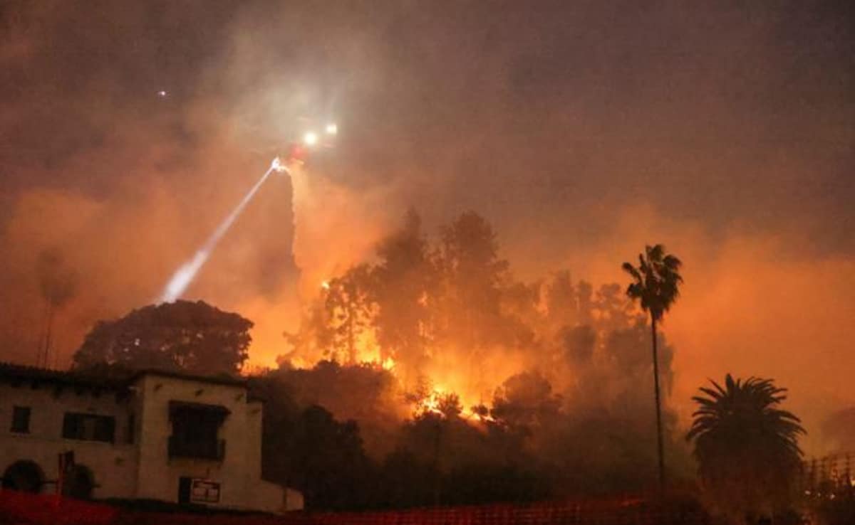 A helicopter performs a water drop, as smoke and flames rise from the Sunset Fire in the hills overlooking the Hollywood neighborhood of Los Angeles A helicopter performs a water drop, as smoke and flames rise from the Sunset Fire in the hills overlooking the Hollywood neighborhood of Los Angeles