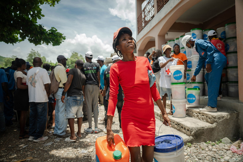 A woman collects relief items distributed by UNICEF. A woman collects relief items distributed by UNICEF.