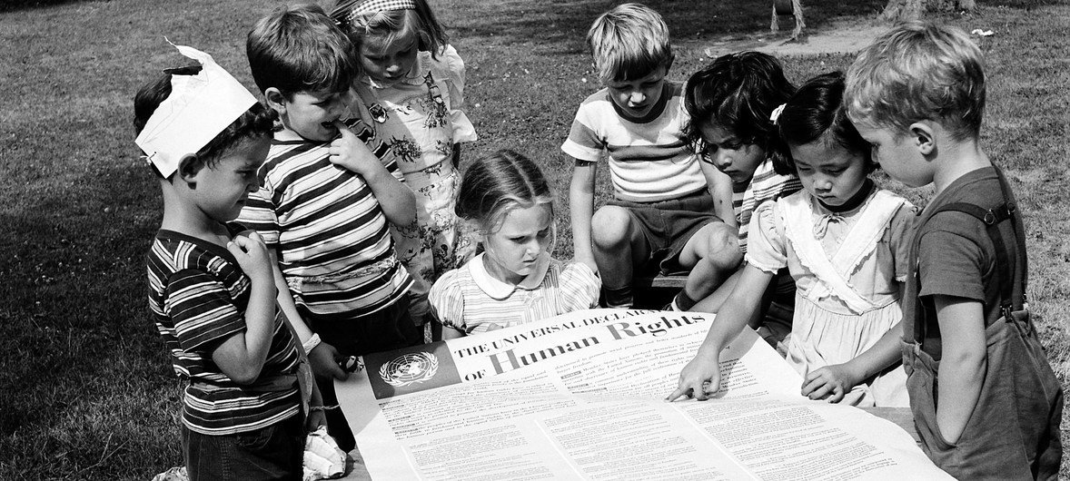 Young children read the Universal Declaration of Human Rights at a playground. (Archive) Young children read the Universal Declaration of Human Rights at a playground. (Archive)