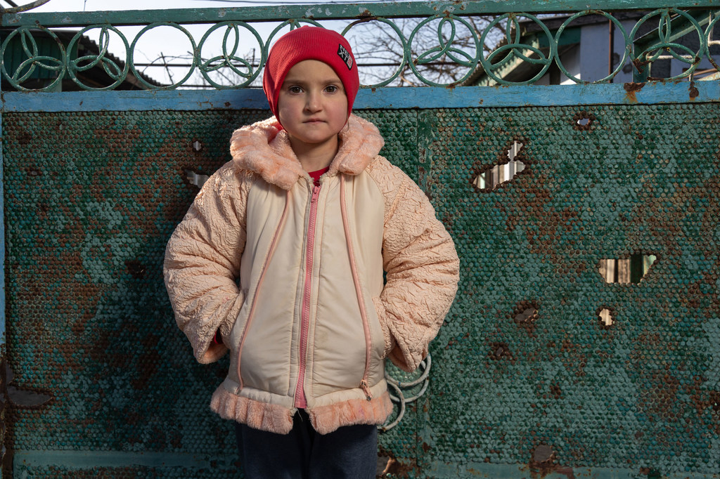 Alina, 12, stands next to her damaged home in Kobzartsi, Mykolaiv region. Alina, 12, stands next to her damaged home in Kobzartsi, Mykolaiv region.