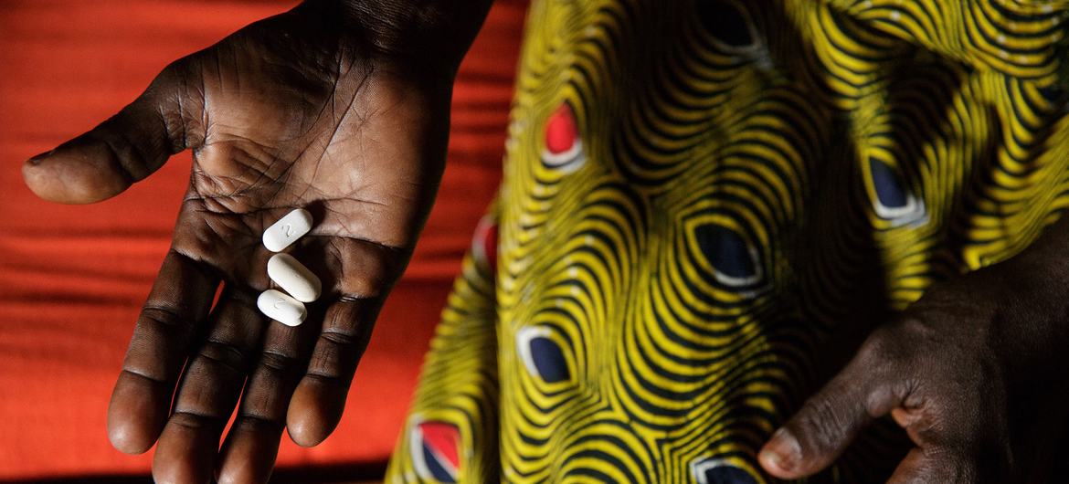 In Côte d’Ivoire, a woman living with HIV holds three pills she takes daily as part of antiretroviral therapy. In Côte d’Ivoire, a woman living with HIV holds three pills she takes daily as part of antiretroviral therapy.