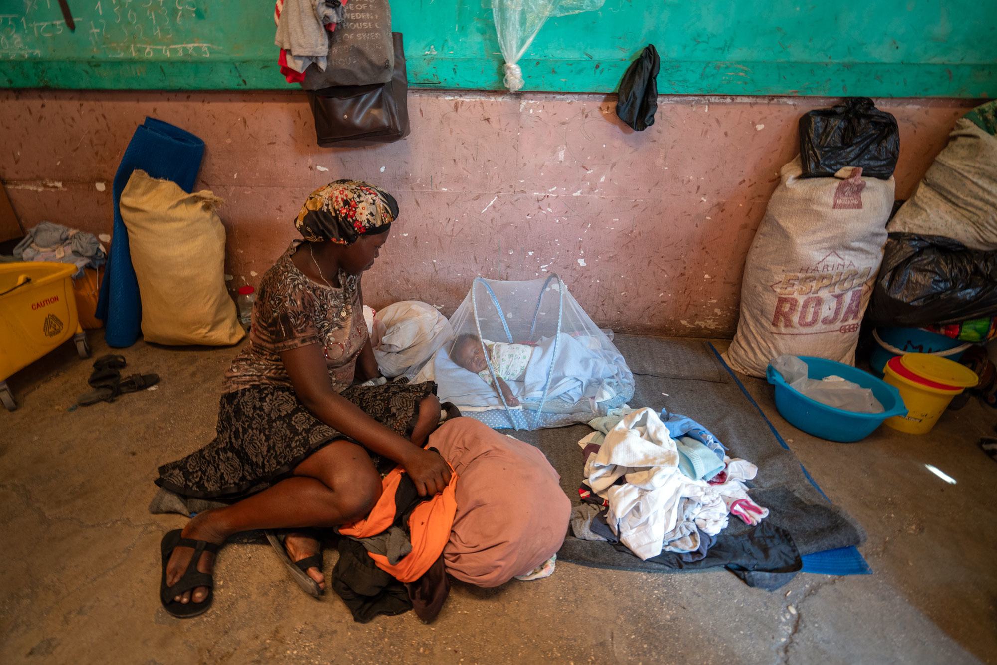 A displaced mother tends for her baby in a former school in downtown Port-au-Prince, Haiti. A displaced mother tends for her baby in a former school in downtown Port-au-Prince, Haiti.