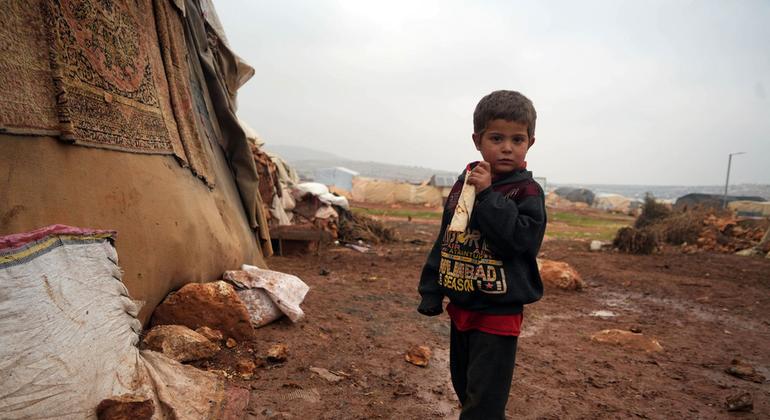 A young boy stands outside a shelter in a camp for displaced people in northern Syria. A young boy stands outside a shelter in a camp for displaced people in northern Syria.