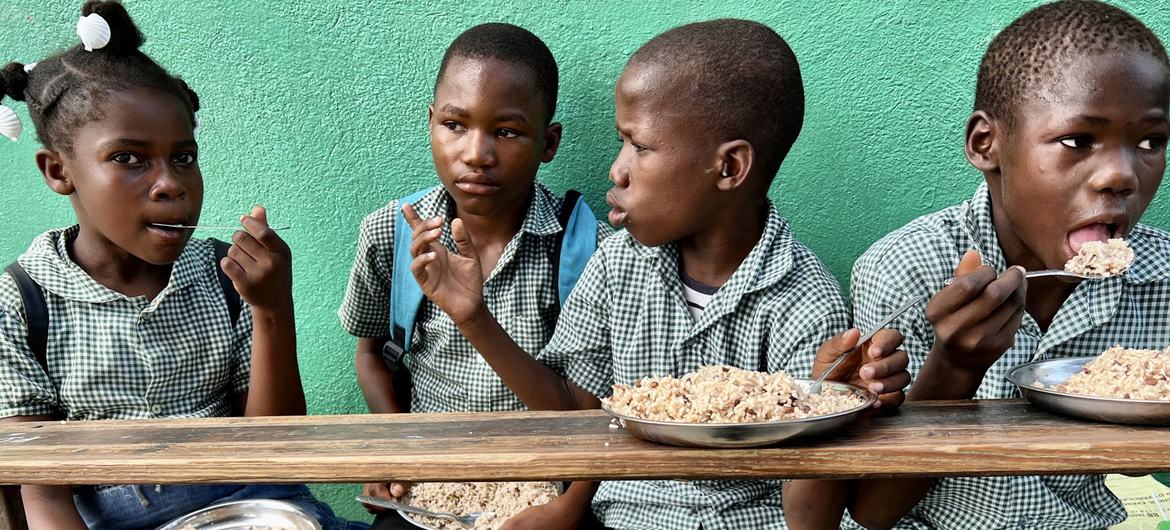 Children in Haiti eat a meal provided as part of WFP's school feeding programme. Children in Haiti eat a meal provided as part of WFP's school feeding programme.