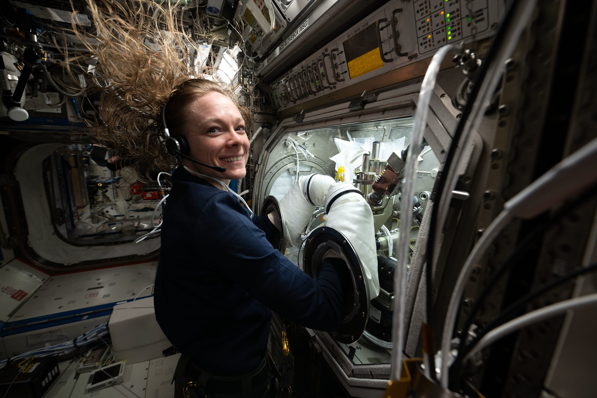 NASA astronaut Nichole Ayers conducts research operations inside the Destiny laboratory module's Microgravity Science Glovebox aboard the International Space Station.