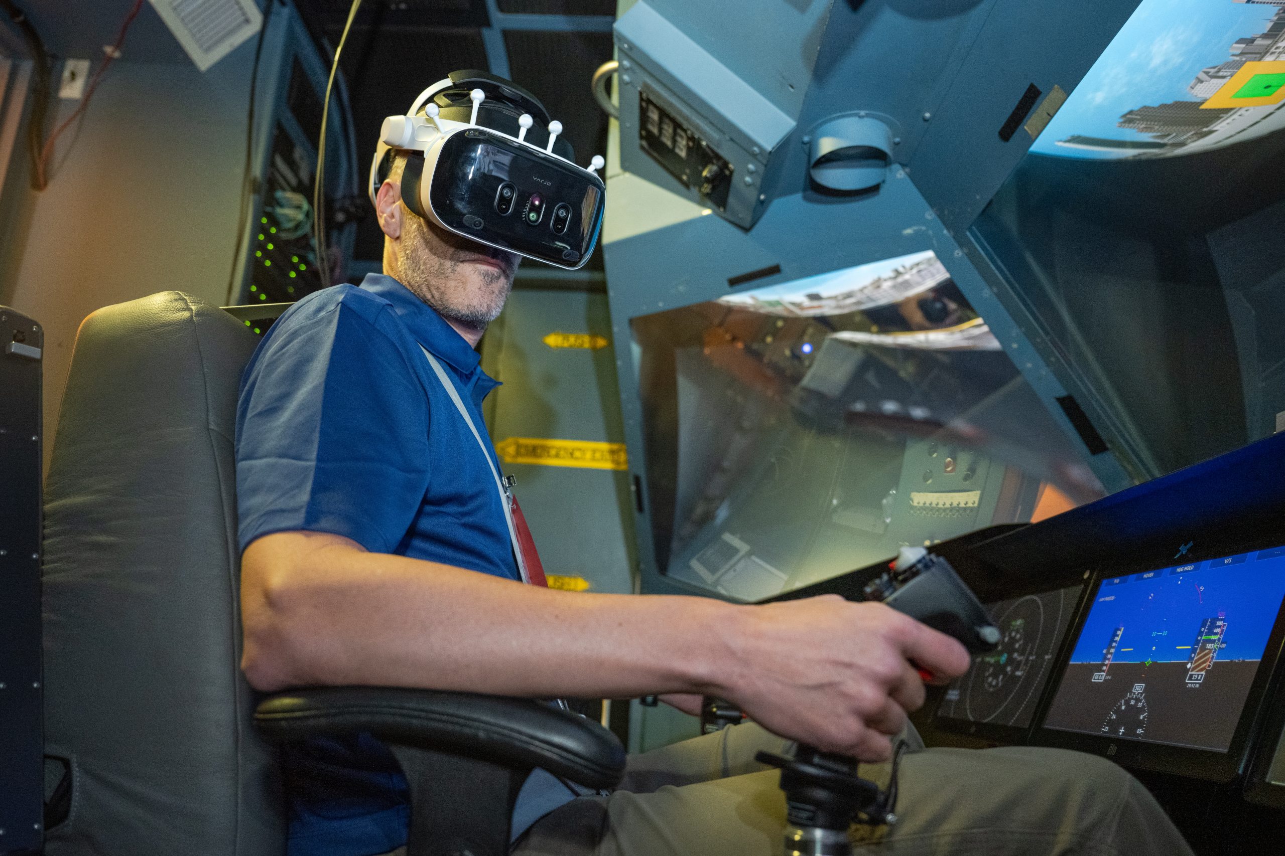 A pilot, Damien Hischier, of the National Test Pilot School dons virtual reality goggles inside a Virtual Motion Simulator at NASA's Ames Research Center.