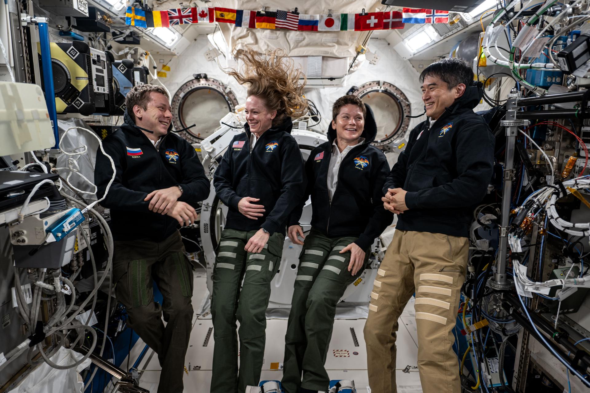 From left, NASA's SpaceX Crew-10 members Kirill Peskov of Roscosmos, NASA astronauts Nichole Ayers and Anne McClain, and JAXA (Japan Aerospace Exploration Agency) astronaut Takuya Onishi share a light moment during a group portrait inside the International Space Station's Kibo laboratory module.
