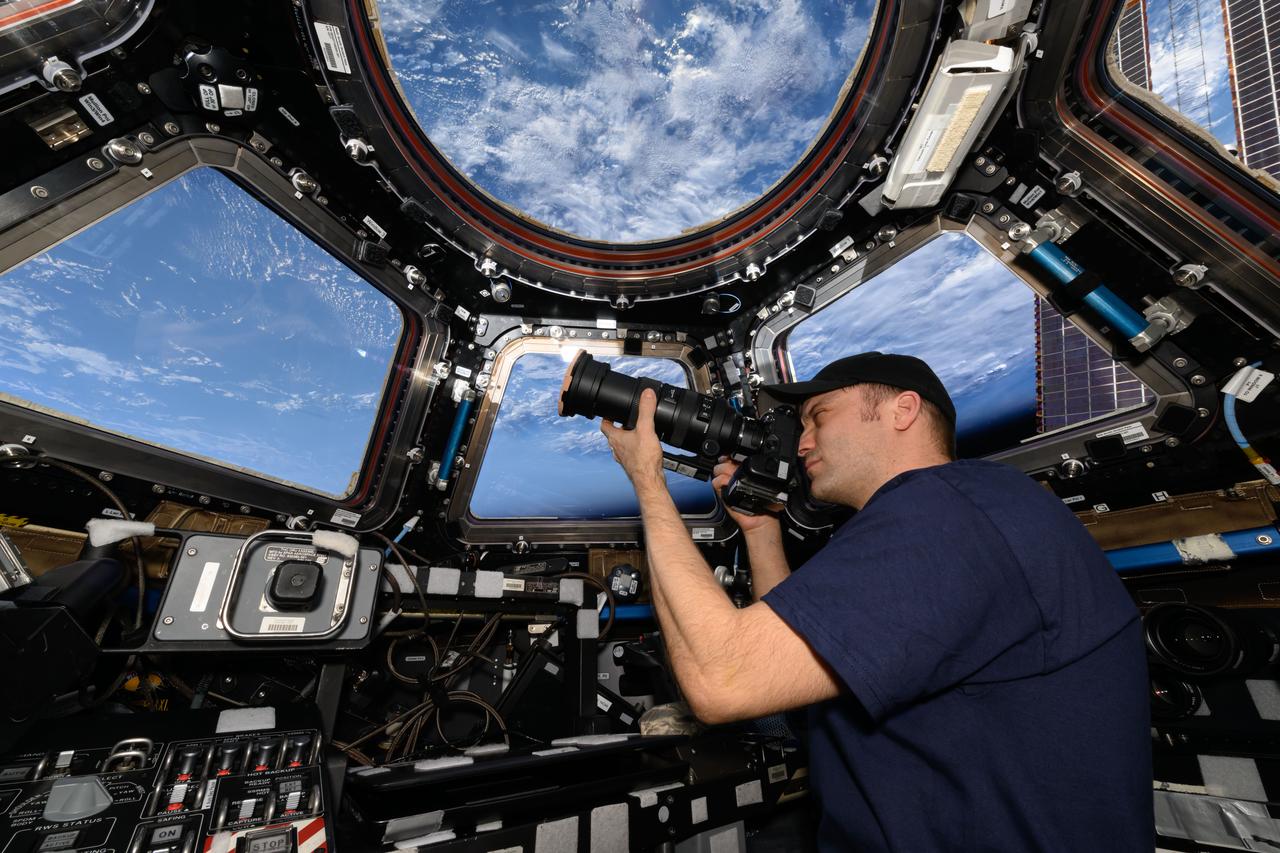 NASA astronaut Matthew Dominick points his camera through a cupola window as the International Space Station orbits 262 miles above the Atlantic Ocean off the coast of Africa.