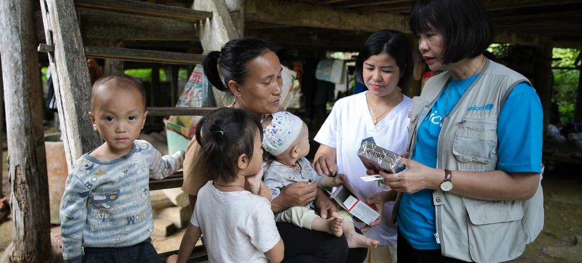 A UNICEF staff member hands ready to eat food to a family in Tuyên Quang, Viet Nam. A UNICEF staff member hands ready to eat food to a family in Tuyên Quang, Viet Nam.