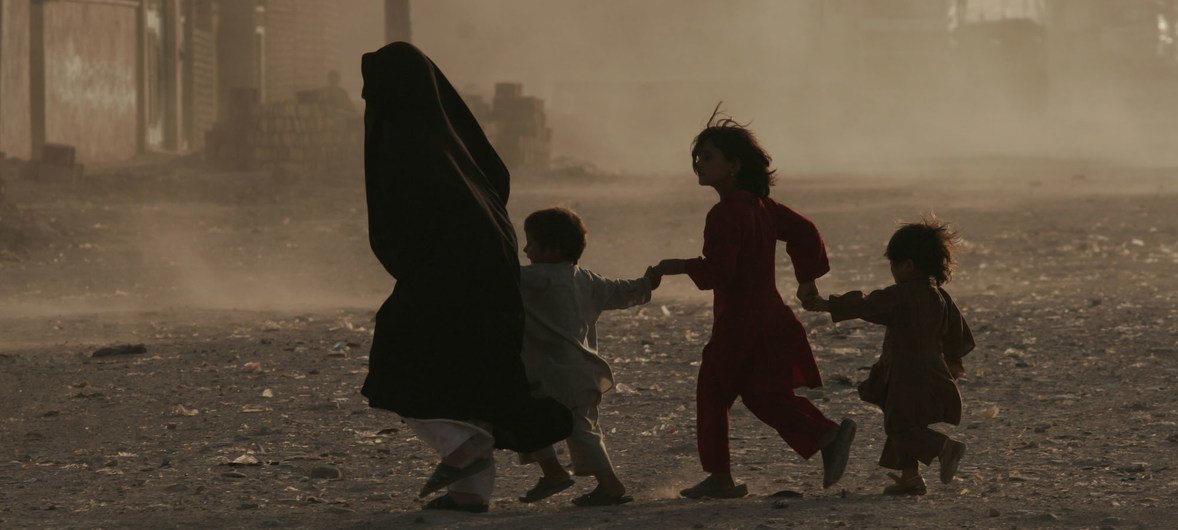 A family runs across a dusty street in Herat, Afghanistan. A family runs across a dusty street in Herat, Afghanistan.
