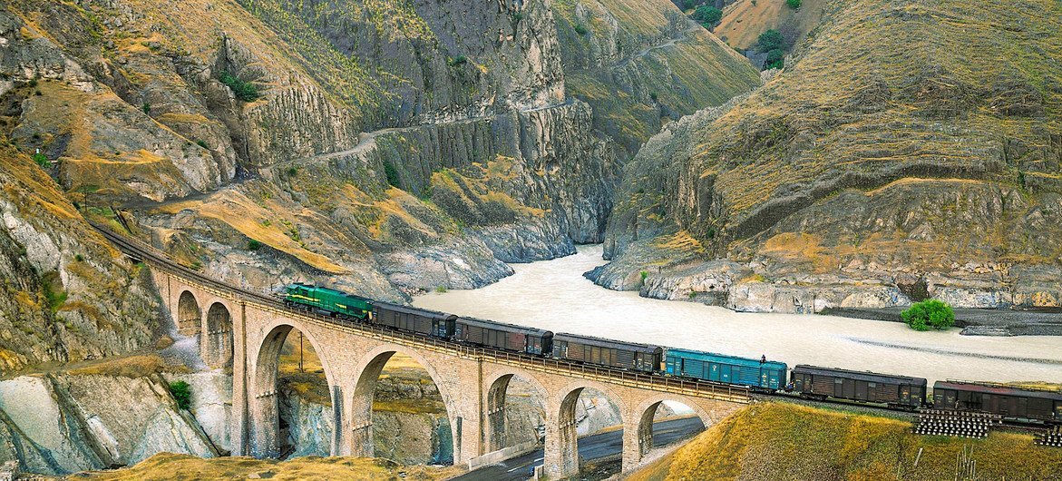 A locomotive freight train traverses the Absirom Bridge on the Trans-Iranian Railway in Iran.