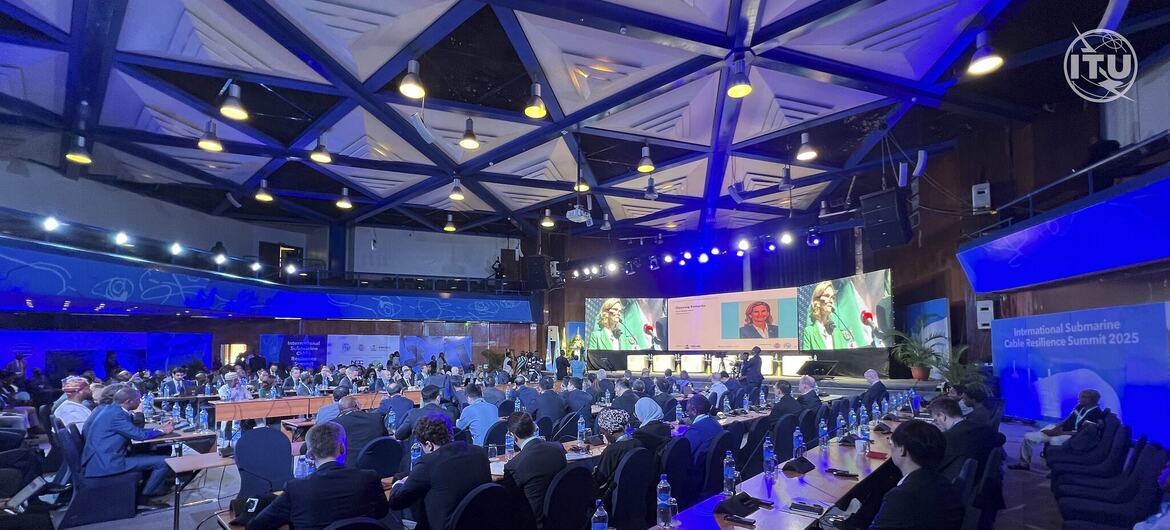 Attendees at the International Submarine Cable Resilience Summit 2025, hosted by ITU, seated in a large conference hall with screens displaying speakers.