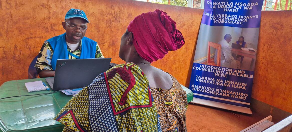 A woman consults with an UNHCR aid worker at a voluntary repatriation help desk in Tanzania, where information and counseling are provided for Burundian refugees.